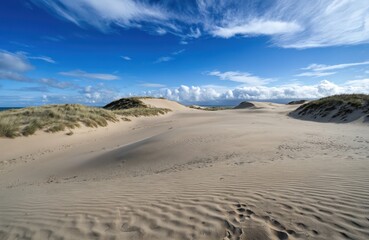 Serene beach with light brown sand dunes. Baltic Sea coast in Poland. Summer landscape with blue sky, white clouds, calm water. Peaceful atmosphere, sandy shore.