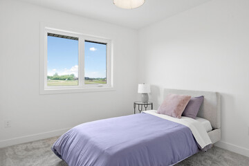 Bedroom with a white bed and a purple comforter