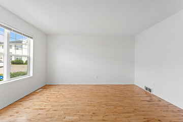 Large empty room with a window and a white wall