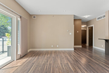 Large open living room with a tan wall and wooden floors