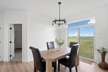 Large wooden dining table with four black chairs around it