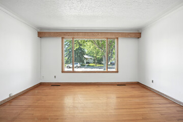 Large, empty living room with a large window