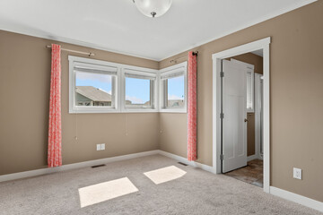 Room with a white door and a window with red curtains