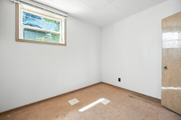 Fototapeta premium Small, empty room with a window and a door