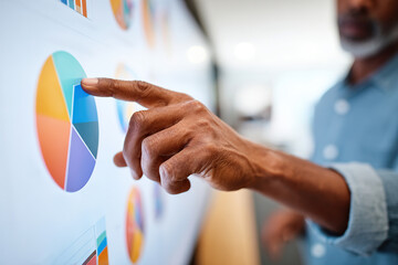 Business professional analyzes data trends on touchscreen display in modern office setting