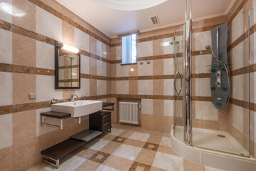 Bright and contemporary bathroom showcases elegant tile work, modern sink and shower fixtures, and...