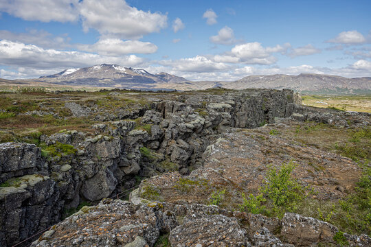 The rift valley between the Eurasian and American tectonic plates in Thingvellir National Park with snow capped mountains in background, in Iceland on 9 June 2025
