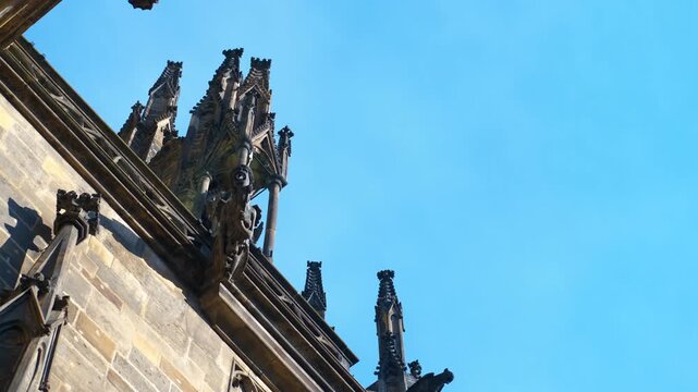 Gargoyles watching over st. Vitus cathedral in prague. Stone gargoyles and other sculptures adorn the roofline of st. Vitus cathedral, a magnificent gothic masterpiece in prague castle