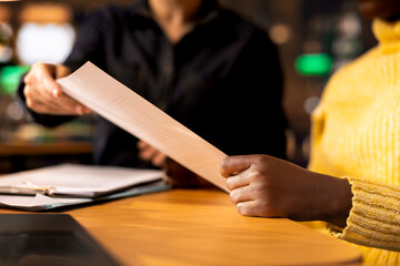 African american student receiving personalized tutoring based on school subjects, focusing on building knowledge to pass upcoming tests. Woman professor mentoring pupil in a library. Close up.