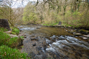 Long exposure of the river Barle flowing through the Barle Valley at Tarr Steps in Exmoor National Park