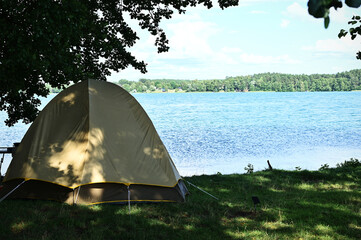 tourist tent on the lake shore on a beautiful summer day