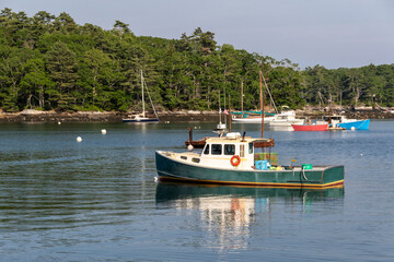 An iconic lobster boat in green and white is seen near McFarland's Cove in South Bristol, Maine, on a late summer afternoon