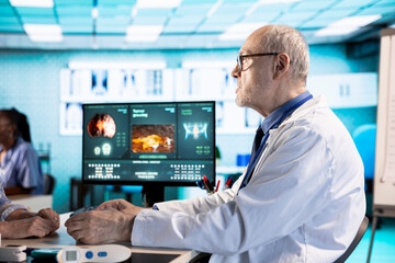 Male specialist examining a female patient in cabinet discussing about treatment plan for recovery,...