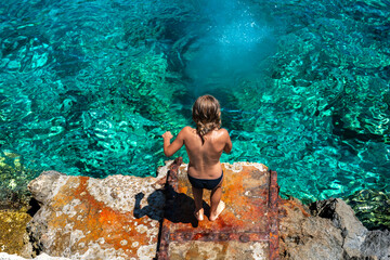 The thrill of summer captured as a young boy dives headfirst into the refreshing Ionian Sea at a...
