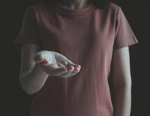 Woman open hand palm facing upward. Gesture of giving, holding, helping, receiving, donation, support, charity, health care, offering product on black background. Empty hand for mock-up presentation.