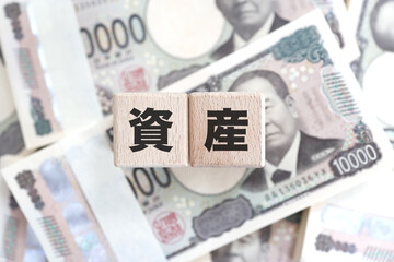 札束と資産の文字ブロック・金融資産や投資のイメージ