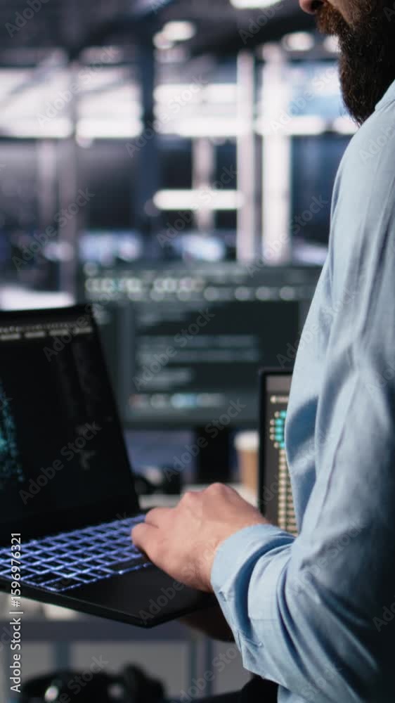 Fototapete vertical video close up of developer in data center coding with generative ai assistance on laptop. 