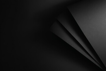 Abstract geometric composition of black layered paper creating a pattern of shadows and lines that gives a sense of depth and texture