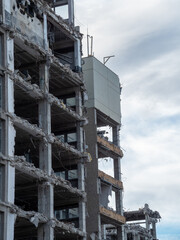 Building demolition process reveals structural details in urban setting during overcast weather