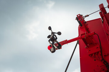 Anemometer on crane main boom, it using for measuring wind speed and direction, indicate for safety lifting operation. Industrial equipment object, close-up with selective focus.