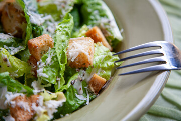 Close-up image of a Caesar salad featuring crisp romaine lettuce, crunchy seasoned croutons, freshly grated Parmesan cheese, and creamy Caesar dressing. Perfect for healthy eating and food lifestyle t