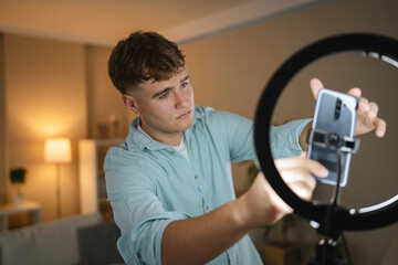 man v-logger set up mobile phone and ring light for live streaming