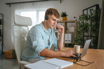 Young man wear headset and work from home on laptop