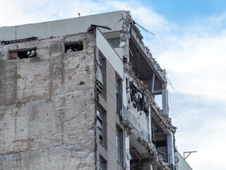 Building devastation shows damage from earthquake in urban area during daylight hours