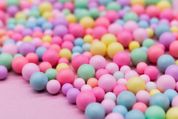 Pastel-colored candy balls in various sizes scattered on a soft background – playful and vibrant flat lay for themes like sweets, childhood, celebration, food styling, and colorful lifestyle concepts
