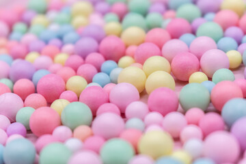 Close-up of pastel-colored candy balls in various sizes on a soft background – playful and vibrant flat lay for themes like sweets, childhood, celebration, food styling, and colorful lifestyle