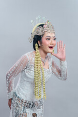 An Indonesian woman in elegant Sundanese bridal attire leans forward with a joyful smile and...