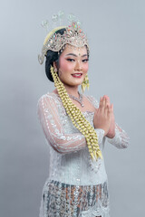 An Indonesian bride wearing Sundanese traditional wedding attire poses with a graceful smile and...