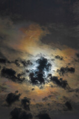 Fototapeta premium Sun shines through high clouds and creates dramatically brilliant multicolored halo