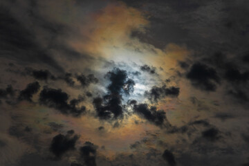 Sun shines through high clouds and creates dramatically brilliant multicolored halo
