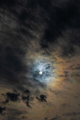 Sun shines through high clouds and creates dramatically brilliant multicolored halo