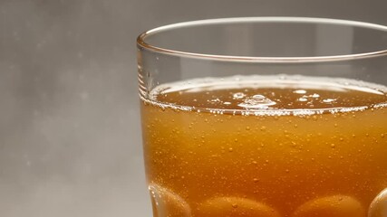Close-up of a glass of amber-colored beverage with bubbles. - Powered by Adobe