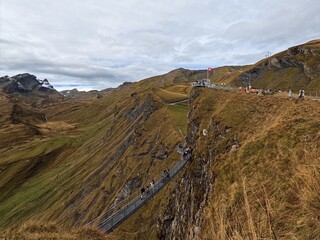 Tourists waiting their turn to take their picture of them in front of Eiger Mountain on the cliff walk at First Grindelwald Switzerland