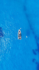 Un petit bateau en plein milieu de la mer Méditerranée avec un eau paradisiaque bleu turquoise  