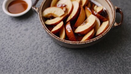 Sliced apples simmering in warm, spiced syrup captured in a rustic pot during an autumn afternoon