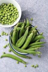 Fresh ripe green peas on grey table, flat lay