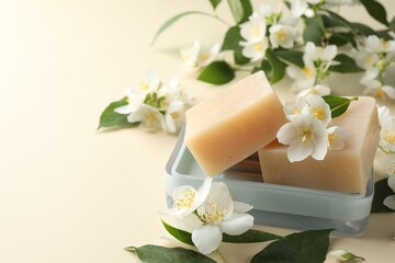 Soap bars and jasmine flowers on beige background, closeup. Space for text