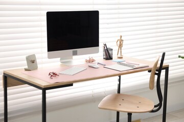 Stylish workplace with wooden desk, stationery and computer at home office