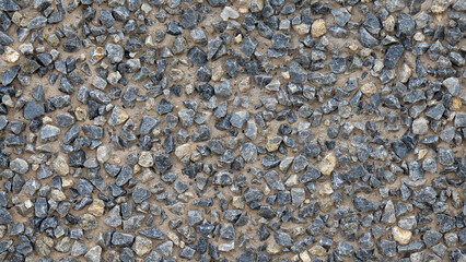 Top view close-up of exposed aggregate surface with gravel stone, small stones in bluish grey tones with cement or concrete for wall, slab, floor, interior, exterior. Cladding, natural texture.