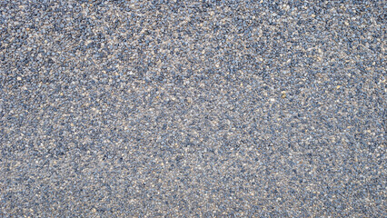 Top view of exposed aggregate surface with gravel stone and small stones in bluish grey tones with cement or concrete for wall, slab, tile, floor, interior, exterior. Cladding, natural texture. 