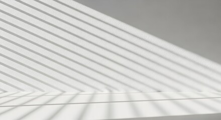 Obraz premium Clean white studio background with diagonal shadow lines from blinds, offering copy space