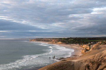 Sunset approaching the coastline of Port Willunga. The beachside is clearly visible with waves gently crashing.
