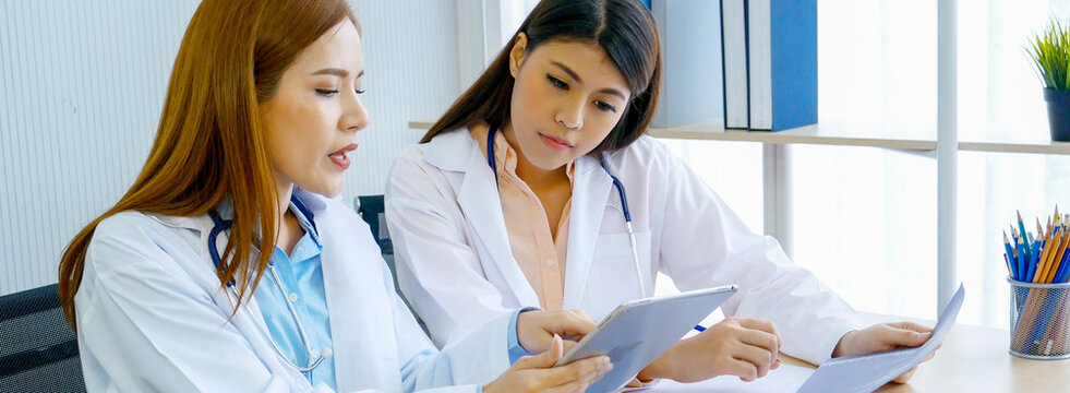 Banner hands of two women doctor medical lab discussing together healthcare teamwork. Panorama Two asian women doctors meeting write prescription medical clinic office using laptop with copy space. - Powered by Adobe