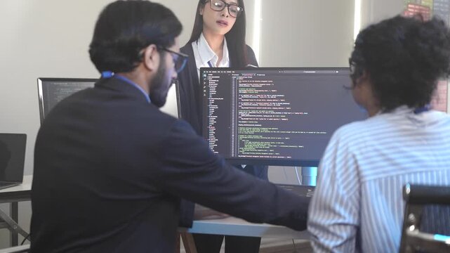 A senior software engineer leads a code review session, mentoring his diverse team on a complex project. Concept for agile development, knowledge transfer, and teamwork.