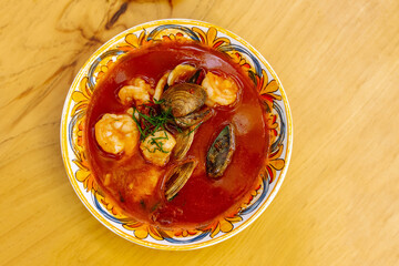 Tasty seafood tomato soup featuring shrimp, clams, and mussels in a vibrant bowl at an Italian eatery.