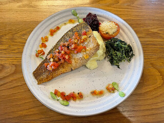 Grilled seabass steak served with spinach, berry jam, vegetables and mashed potatoes